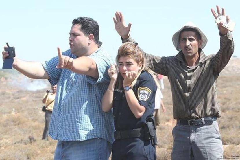 Palestinian nonviolent activists defending Israeli policewoman from Israeli settler attack at Esh Kodesh outpost, August 2015.
